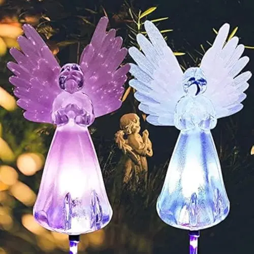 Two solar-powered angel stake lights with multi-color changing LEDs in a garden or gravesite