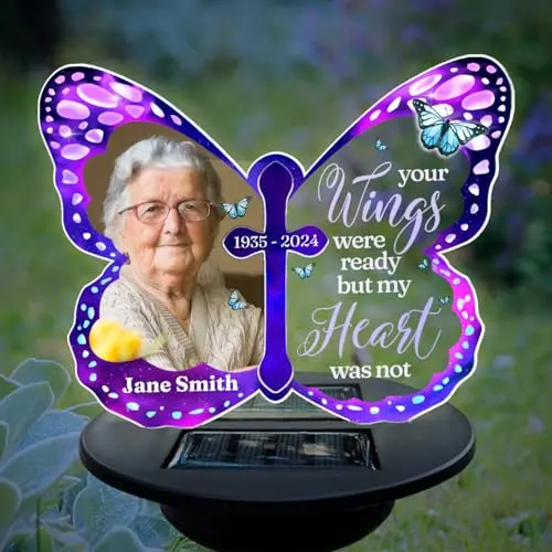 A custom acrylic memorial solar light with a personalized photo, name, and dates, shaped like a butterfly